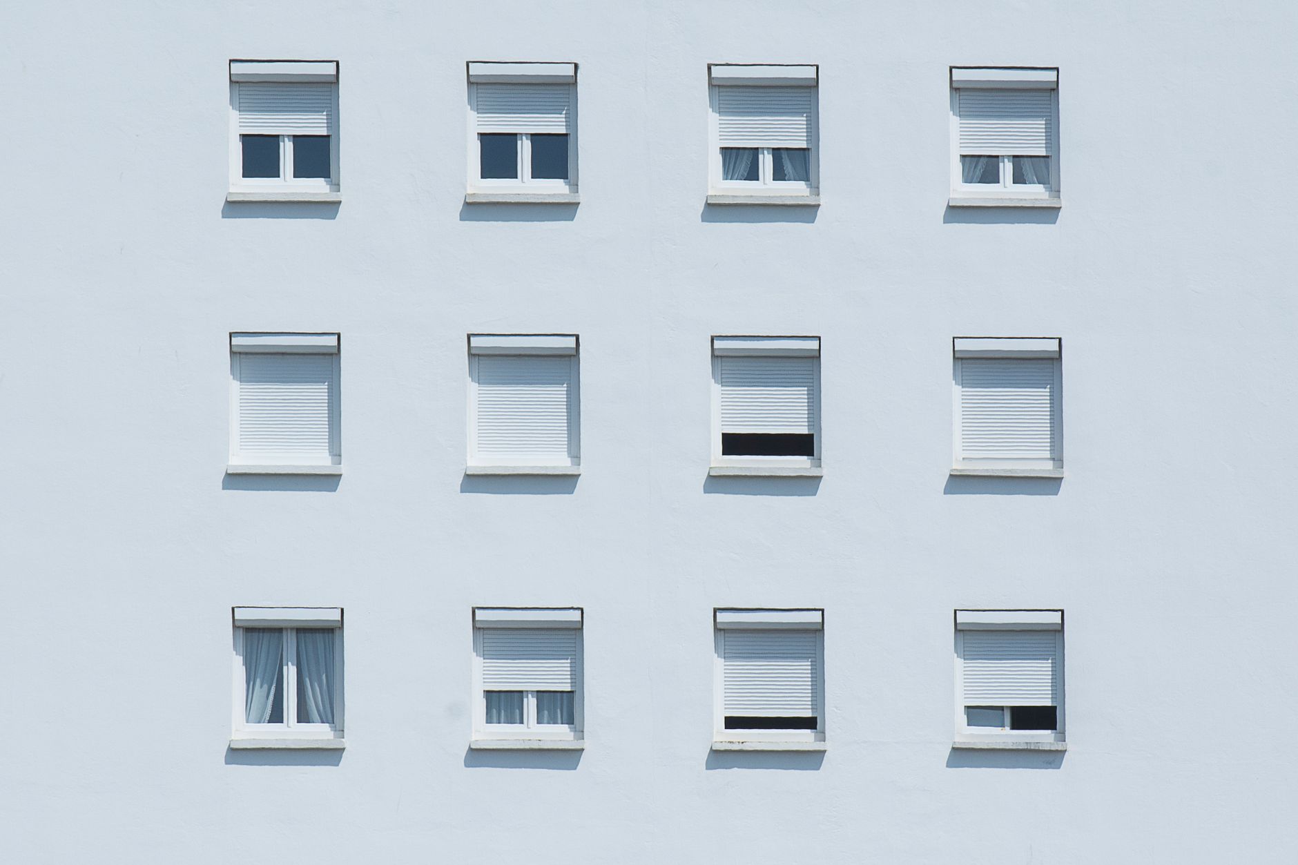 Symmetrical arrangement of windows on a white residential building facade