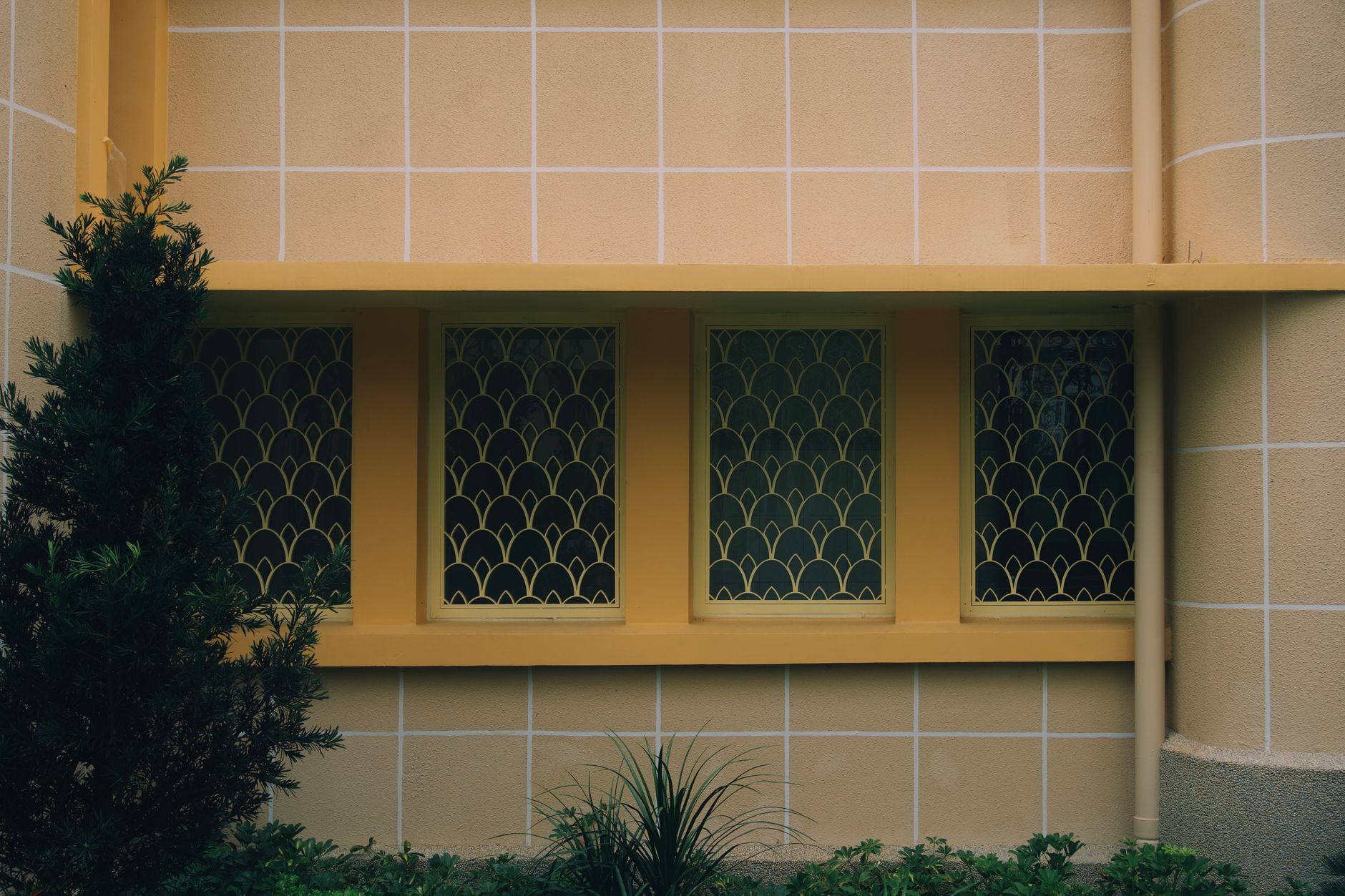 Exterior wall with art deco style windows and geometric yellow grills